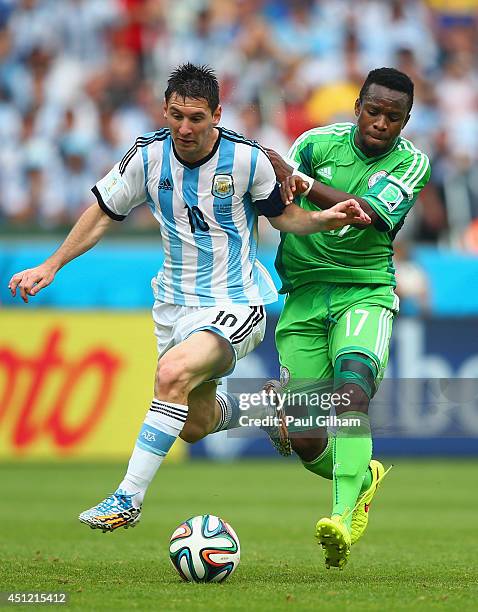 Lionel Messi of Argentina competes for the ball with Ogenyi Onazi of Nigeria during the 2014 FIFA World Cup Brazil Group F match between Nigeria and...