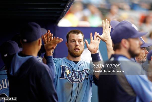 Ben Zobrist of the Tampa Bay Rays celebrates in the dugout after scoring off a single by James Loney of the Tampa Bay Rays during the eighth inning...