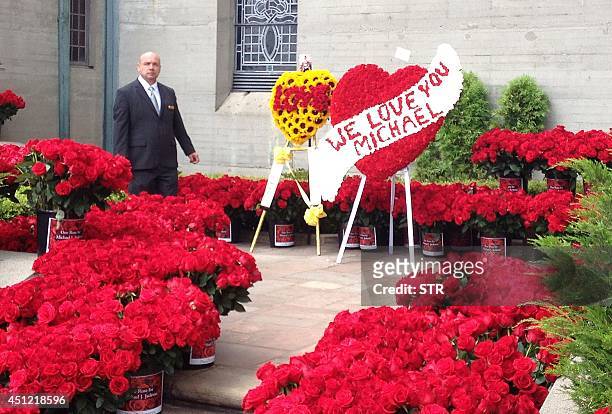 Park employee keeps watch over flowers placed outside the mausoeum of pop music superstar Michael Jackson, June 25, 2014 at the Forest Lawn Memorial...