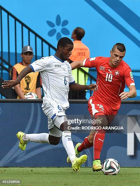 Honduras' defender Juan Carlos Garcia vies with Switzerland's midfielder Granit Xhaka during a Group E football match between Honduras and...