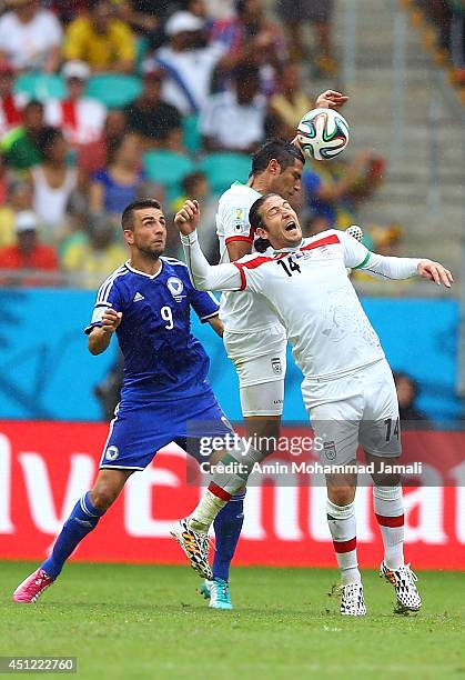 Andranik Teymourian and Amir Hossein Sadeghi of Iran and Vedad Ibisevic of Bosnia in action during the 2014 FIFA World Cup Brazil Group F match...