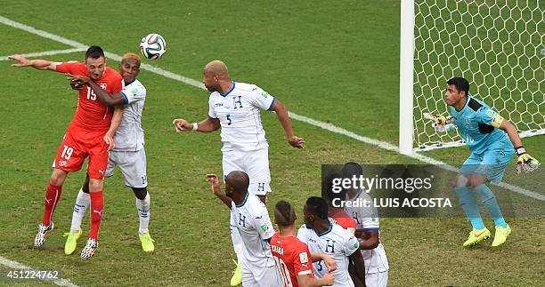 Honduras' goalkeeper Noel Valladares eyes the ball as Switzerland's forward Josip Drmic jumps for a header during the Group E football match between...
