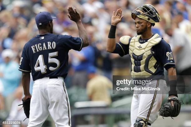 Alfredo Figaro of the Milwaukee Brewers celebrates with Martin Maldonado after the 9-2 win over the Washington Nationals at Miller Park on June 25,...