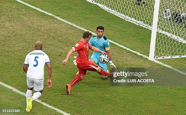 Switzerland's midfielder Xherdan Shaqiri has a shot at the goal in front of Honduras' defender Victor Bernardez and Honduras' goalkeeper and captain...