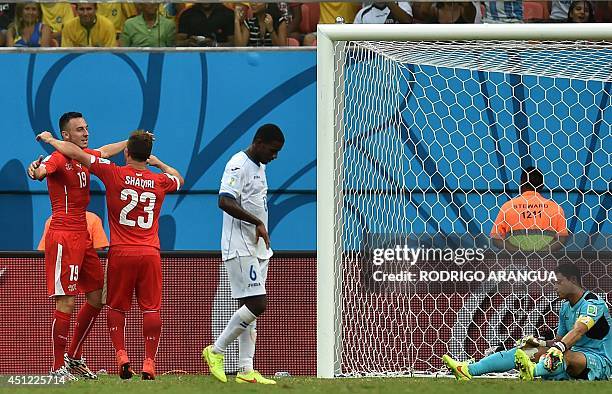Switzerland's midfielder Xherdan Shaqiri celebrates with forward Josip Drmic next to Honduras' goalkeeper Noel Valladares after scoring his team's...