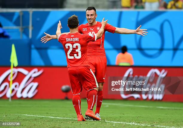 Xherdan Shaqiri of Switzerland celebrates scoring his team's third goal with his teammate Josip Drmic of Switzerland to complete his hat trick during...