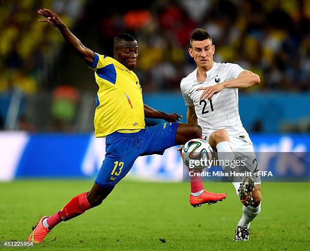 Enner Valencia of Ecuador and Laurent Koscielny of France compete for the ball during the 2014 FIFA World Cup Brazil Group E match between Ecuador...