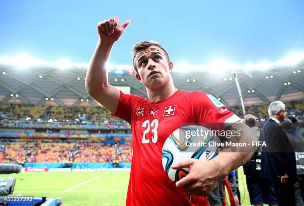 Xherdan Shaqiri of Switzerland walks off the pitch with the match ball as he completed a hat trick after the 3-0 win in the 2014 FIFA World Cup...