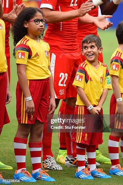 Player escort smiles prior to the 2014 FIFA World Cup Brazil Group E match between Honduras and Switzerland at Arena Amazonia on June 25, 2014 in...