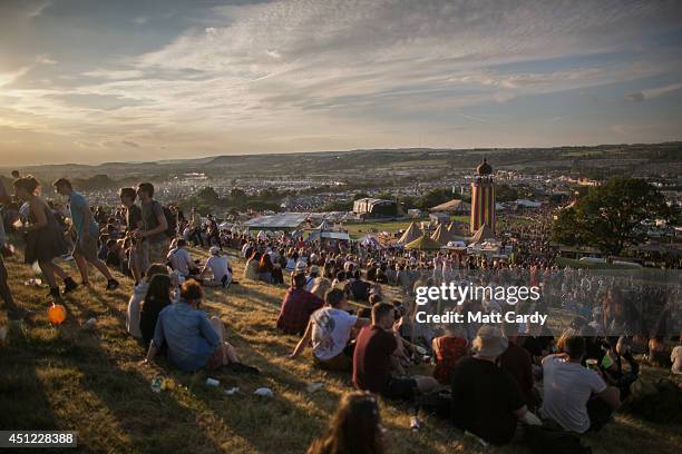 People gather to watch the sun set at Worthy Farm in Pilton on the first day of the 2014 Glastonbury Festival on June 25, 2014 in Glastonbury,...