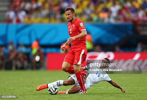 Jorge Claros of Honduras tackles Haris Seferovic of Switzerland during the 2014 FIFA World Cup Brazil Group E match between Honduras and Switzerland...