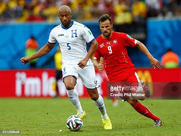 Victor Bernardez of Honduras controls the ball as Haris Seferovic of Switzerland gives chase during the 2014 FIFA World Cup Brazil Group E match...