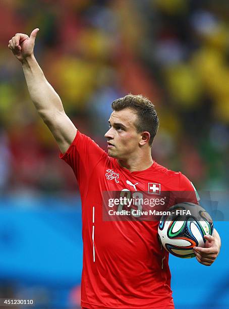 Xherdan Shaqiri of Switzerland walks off the pitch with the match ball as he completed a hat trick after the 3-0 win in the 2014 FIFA World Cup...
