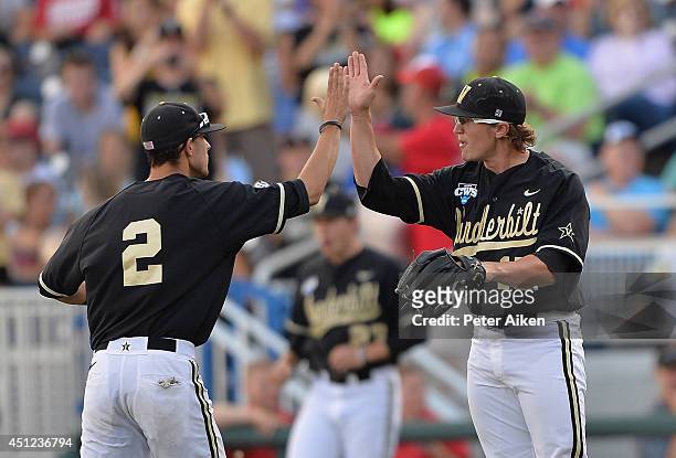 Pitcher Carson Fulmer of the Vanderbilt Commodores reacts to getting the final out against the Virginia Cavaliers in the first inning with teammate...