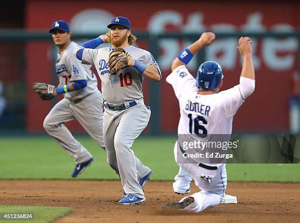 Justin Turner of the Los Angeles Dodgers gets the force out on Billy Butler of the Kansas City Royals and throws to first on a double play attempt in...