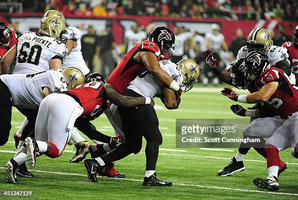 Pierre Thomas of the New Orleans Saints carries the ball against Stansly Maponga, Corey Peters, and Sean Weatherspoon of the Atlanta Falcons at the...