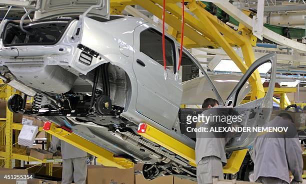 Employees of the Avtoframos automobile plant assemble a Renault Logan model in Moscow 05 April 2005. The French automaker Renault launched production...