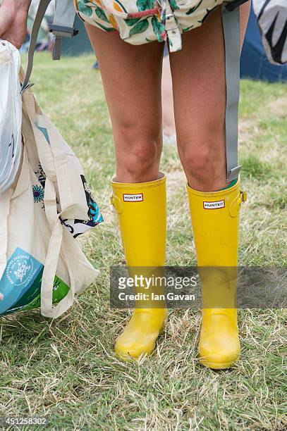 Festival-goer wears wellington boots in preparation for rain during the Glastonbury Festival at Worthy Farm on June 26, 2014 in Glastonbury, England.