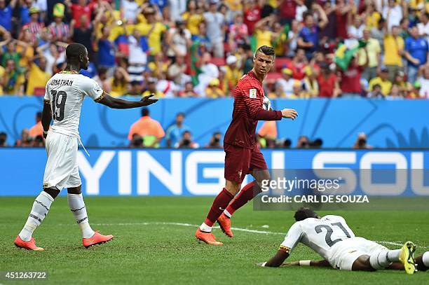 Portugal's forward and captain Cristiano Ronaldo runs with the ball as Ghana's defender Jonathan Mensah and Ghana's defender John Boye react after...