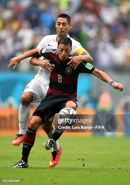 Mesut Oezil of Germany and Clint Dempsey of the United States compete for the ball during the 2014 FIFA World Cup Brazil Group G match between USA...