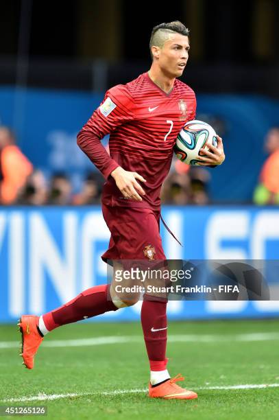 Cristiano Ronaldo of Portugal picks up the ball from the net after their first goal for a quick restart during the 2014 FIFA World Cup Brazil Group G...