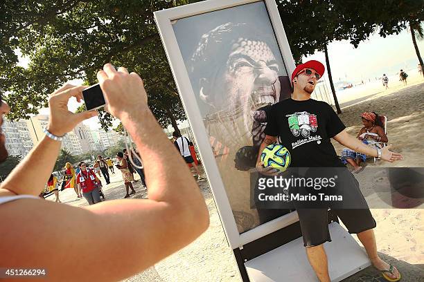 Man taks a photo next to an advertisement featuring Uruguay's Luis Suarez, mocking the biting incident against opponent Giorgio Chiellini during the...