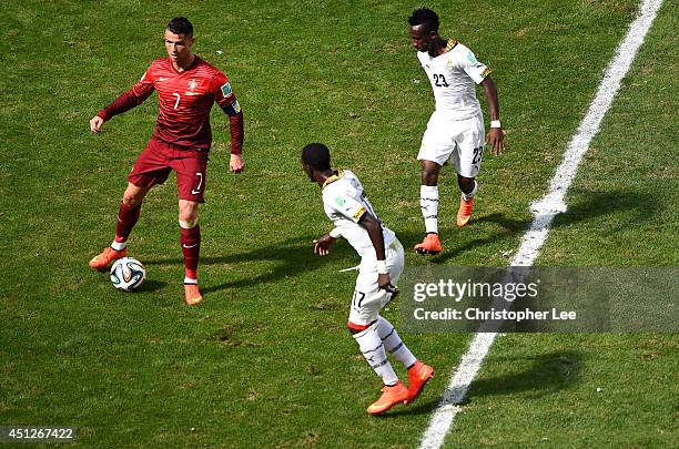 Cristiano Ronaldo of Portugal controls the ball as Mohammed Rabiu and Harrison Afful of Ghana give chase during the 2014 FIFA World Cup Brazil Group...