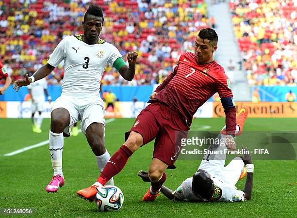 Cristiano Ronaldo of Portugal competes for the ball against Asamoah Gyan and Mohammed Rabiu of Ghana during the 2014 FIFA World Cup Brazil Group G...