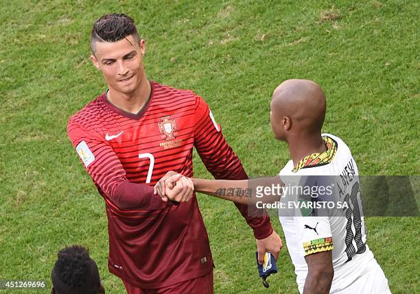 Portugal's forward and captain Cristiano Ronaldo shakes hands with Ghana's midfielder Andre Ayew at the end of the Group G football match between...