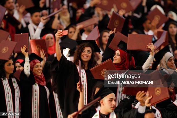 Palestinian student takes a selfie as she attends her graduation ceremony at Birzeit University near the West Bank city of Ramallah, as some 2500...