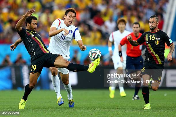 Kim Shin-Wook of South Korea competes for the ball against Moussa Dembele and Steven Defour of Belgium during the 2014 FIFA World Cup Brazil Group H...