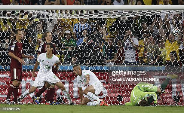 Algeria's forward Islam Slimani and Algeria's defender Aissa Mandi celebrate after Slimani scored his team's first goal past Russia's goalkeeper Igor...