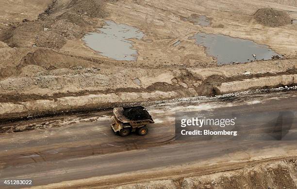 Truck drives through the Syncrude Canada Ltd. Mine in this aerial photograph taken above the Athabasca Oil Sands near Fort McMurray, Alberta, Canada,...