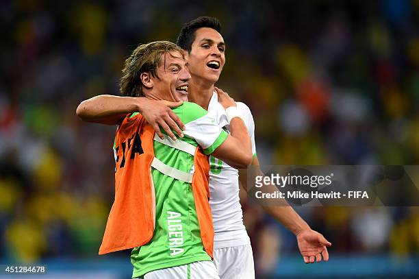 Mehdi Mostefa and Aissa Mandi of Algeria celebrate after a 1-1 draw during the 2014 FIFA World Cup Brazil Group H match between Algeria and Russia at...
