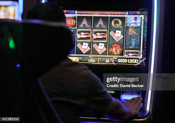 Casino patron Manuel Guzman of California plays the slot machine, "The Magic of David Copperfield," by Bally Technologies at the MGM Grand...