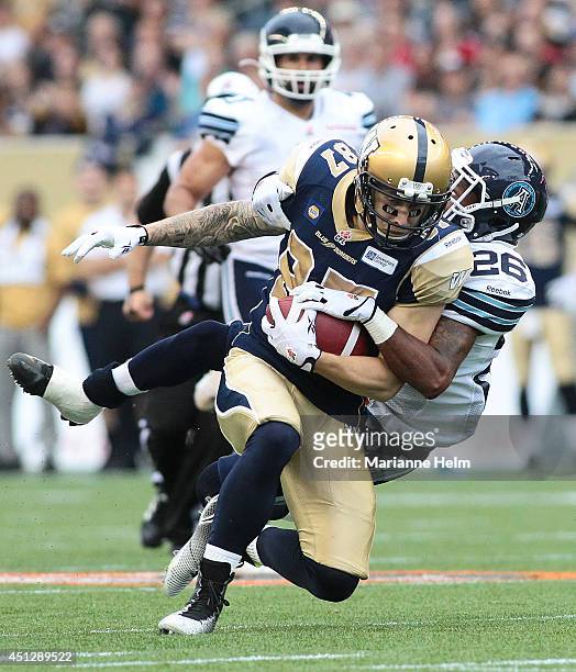 Brendan Smith of the Toronto Argonauts takes down Rory Kohlert of the Winnipeg Blue Bombers in first half action in a CFL game at Investors Group...