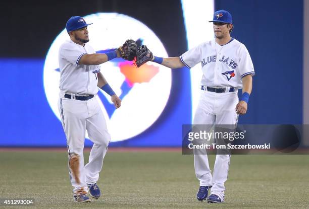 Melky Cabrera of the Toronto Blue Jays celebrates their victory with Colby Rasmus during MLB game action against the Chicago White Sox on June 26,...