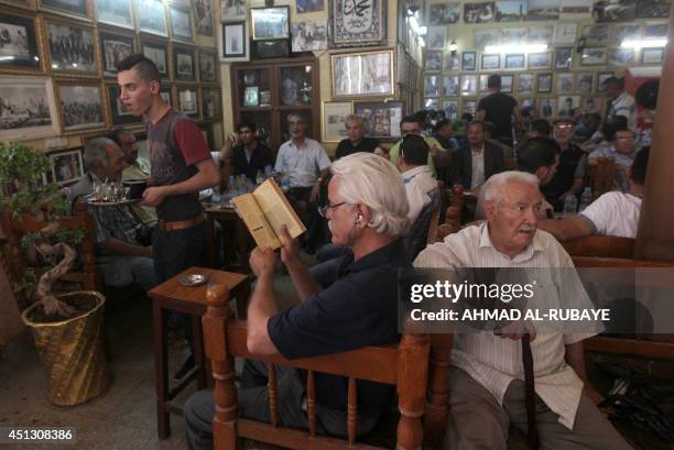 Iraqis sit at the famous Shahbandar cafe on Mutanabi street, known for hosting Iraq's top elite thinkers and poets, on June 27, 2014 in the capital...