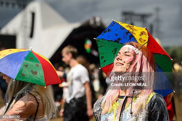 Festival goer looks towards the sun as she stands near to the Pyramid Stage on the first official day of the Glastonbury Festival of Music and...