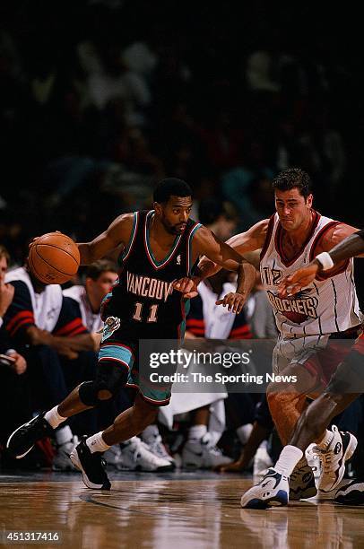 Lee Mayberry of the Vancouver Grizzlies moves the ball past Matt Maloney of the Houston Rockets during the game on December 16, 1997 at the Compaq...