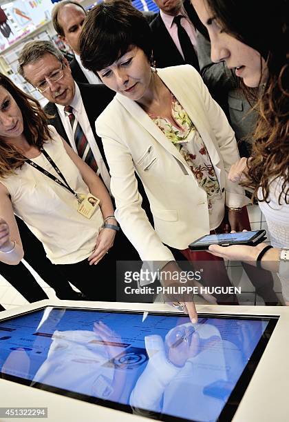 French Trade and Handicraft Junior Minister Carole Delga touches a digital information board as she visits a trade center on June 27 in...