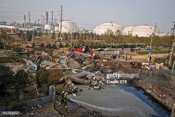 Chinese rescuers search for survivors after an oil pipeline exploded, ripping roads apart, turning cars over and sending thick black smoke billowing...