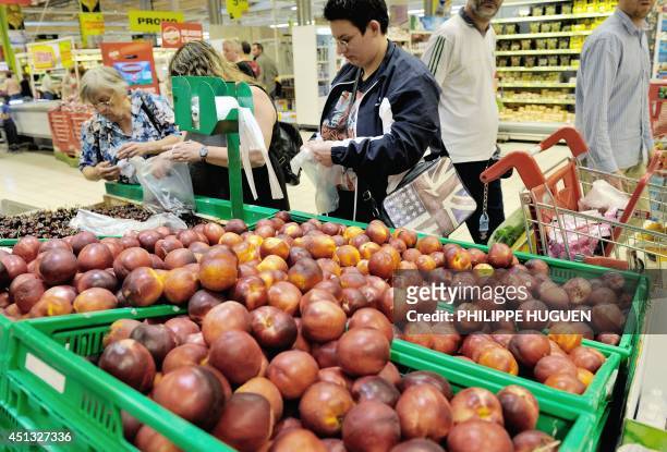 Consumers buy nectarines and cherries at the fruits section in an Auchan supermarket, a branch of the French international retail group Auchan, on...