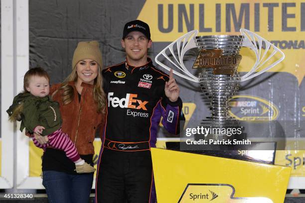 Denny Hamlin, driver of the FedEx Express Toyota, celebrates in victory lane with Jordan Fish and daughter Taylor during the NASCAR Sprint Cup Series...