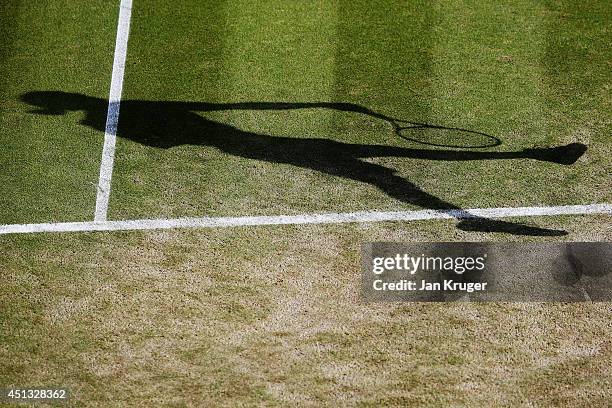 Detail shot of the shadow of Alexandr Dolgopolov of Ukraine serving during his Gentlemen's Singles third round match against Grigor Dimitrov of...