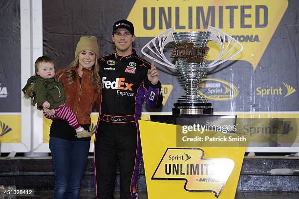 Denny Hamlin, driver of the FedEx Express Toyota, celebrates in victory lane with Jordan Fish and daughter Taylor during the NASCAR Sprint Cup Series...