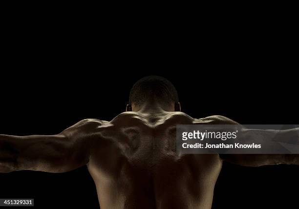 rare view of athletic male, arms outstretched - black male bodybuilders foto e immagini stock