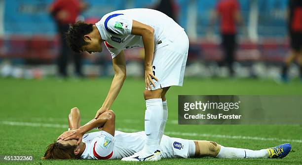 Younggwon Kim of South Korea reacts as team mate Seokho Hwang offers a hand after the 2014 FIFA World Cup Brazil Group H match between South Korea...