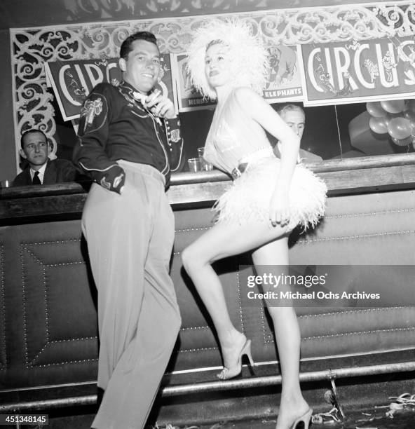 Conrad Hilton, Jr with guest attends Sonja Henie Circus party in Los Angeles, California.