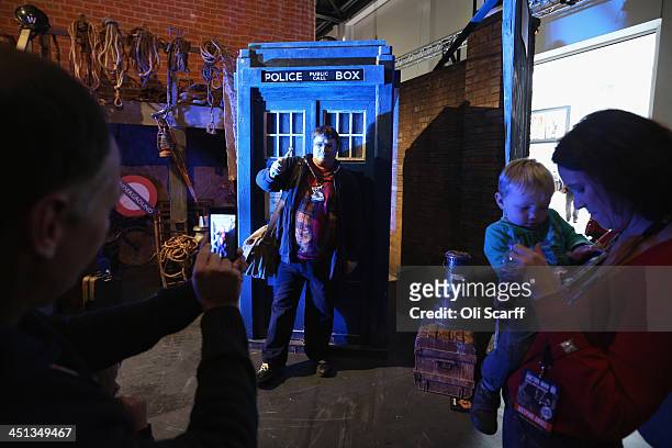 Doctor Who fans pose for a photograph in front of a model of the TARDIS at the 'Doctor Who 50th Celebration' event in the ExCeL centre on November...